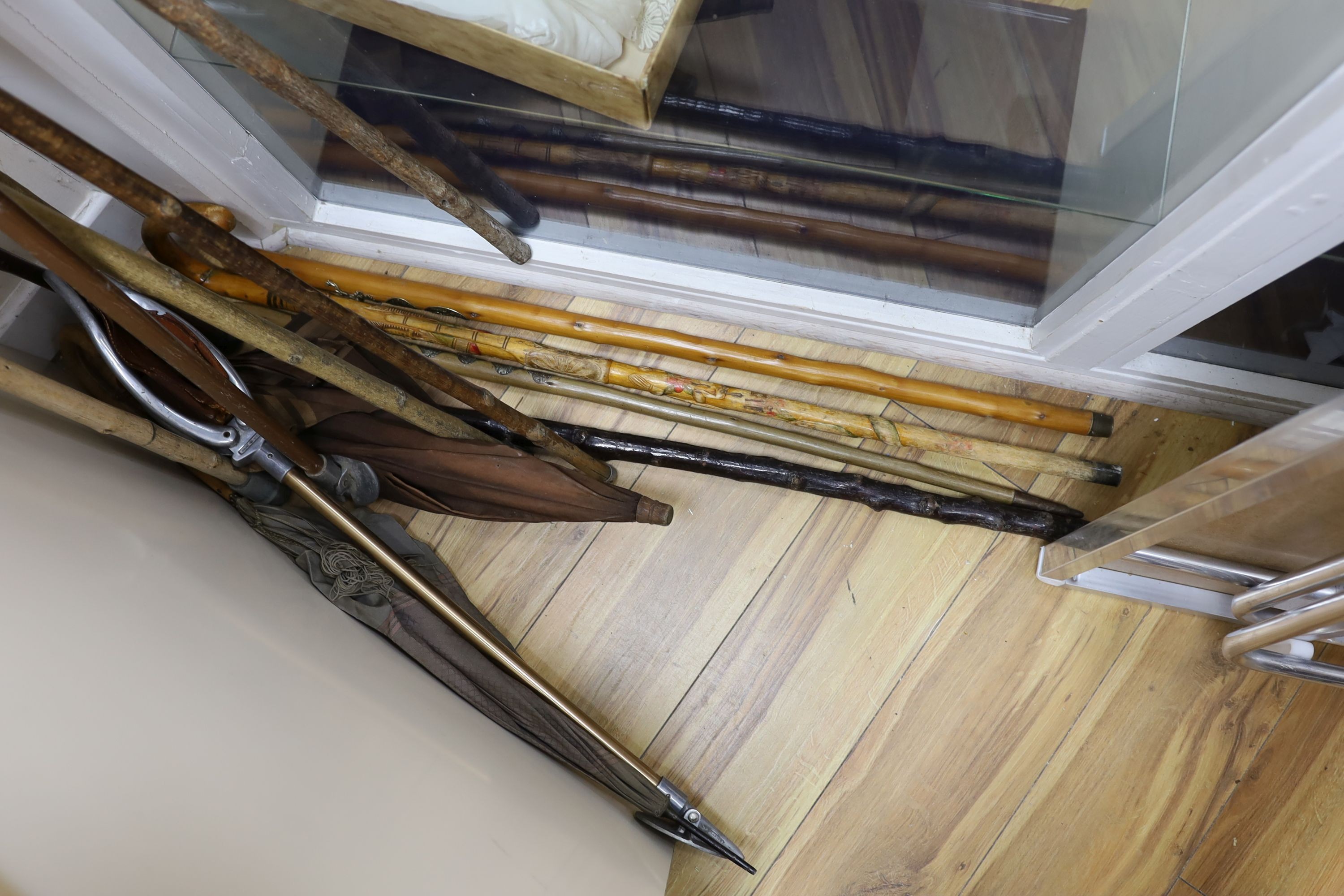 A quantity of various walking and shooting sticks